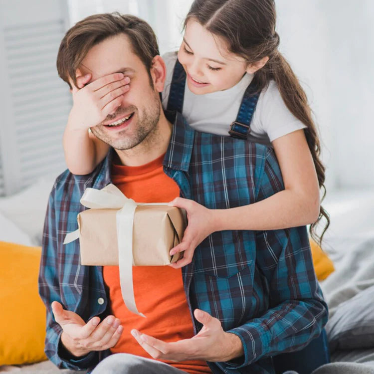 Kind überreicht Papa eine verpackte Fulima Tasse als Geschenk